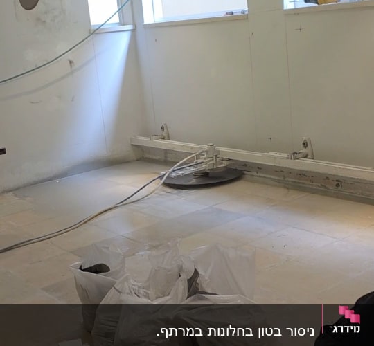 חדר עם ציוד ניסור בטון ועובד באתר בנייה